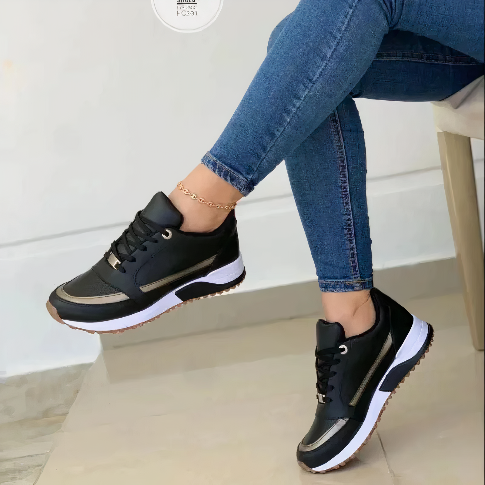 Black lace-up trainers with metallic-looking trim around the toe and sides.