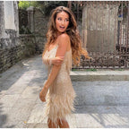 Pale gold fringe dress with feather trim, shown in a side view outdoors.