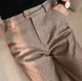 Front view of brown-toned pleated trousers.