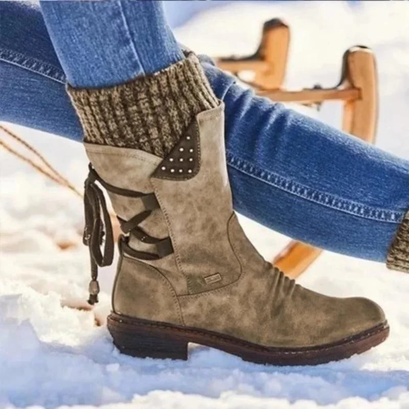 Khaki knit-cuff boots shown with jeans on a snowy surface.