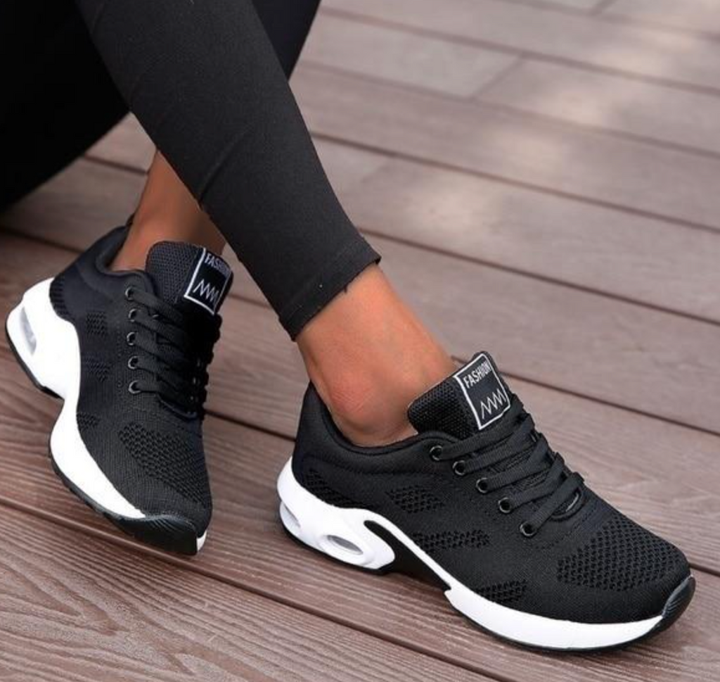 Black lace-up mesh trainers with white curved sole panels.