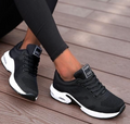 Black lace-up mesh trainers with white curved sole panels.