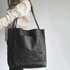 Black shoulder tote worn with a white blouse.