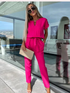 Full-length view of the rose-red jumpsuit and tapered legs.