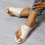 Side view of white sandals showing the open heel and layered upper.