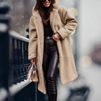 Apricot long coat worn open over black trousers.