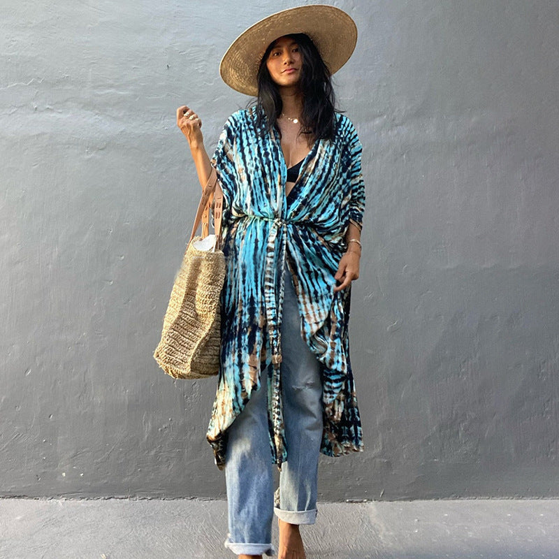 Blue printed cover-up tied over a white top and jeans.