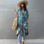 Blue printed cover-up tied over a white top and jeans.
