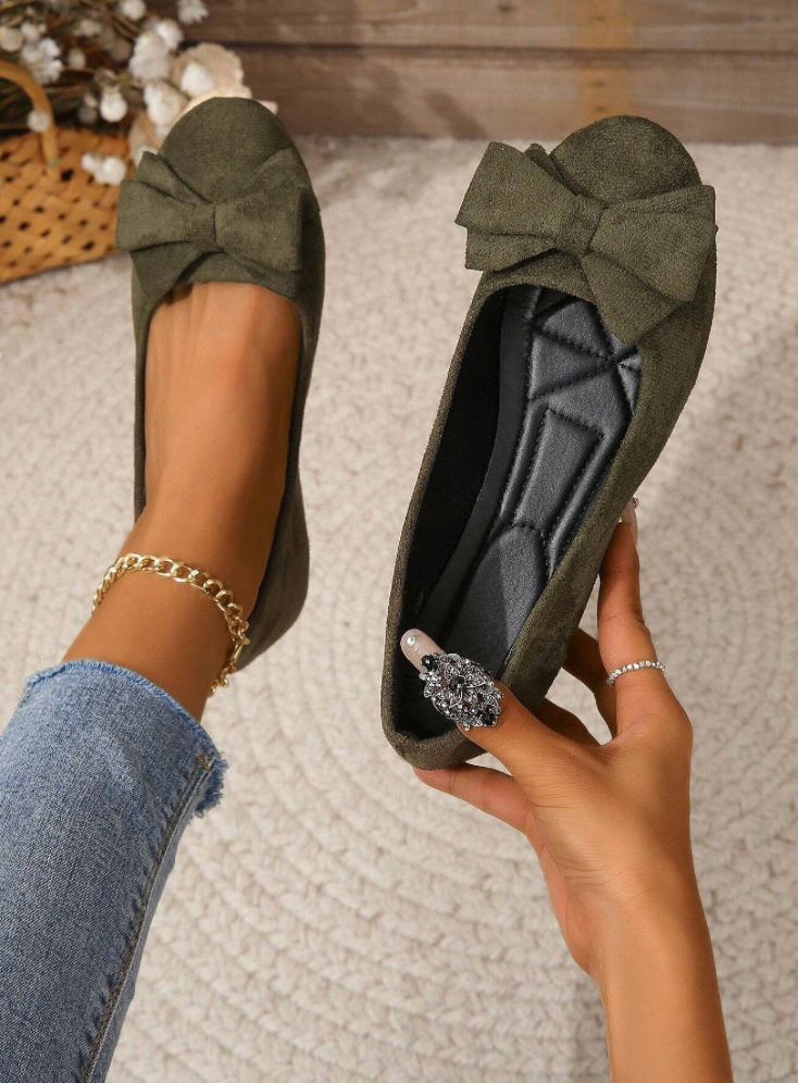 Dark green flat held to show the shaped black insole.