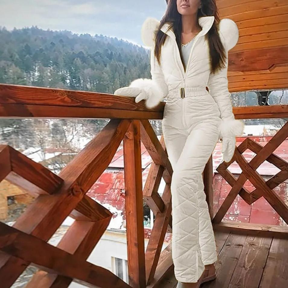 White quilted jumpsuit with long flared legs, shown on a wooden balcony.