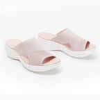 Pair of pale pink slide sandals shown from above.