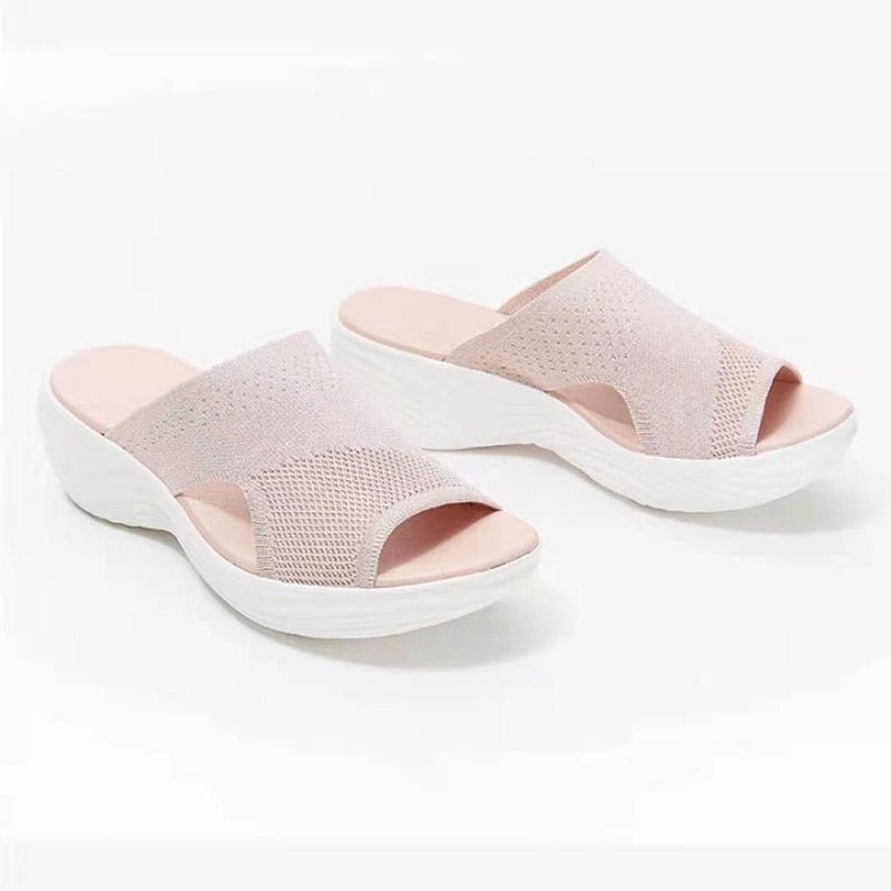 Pair of pale pink slide sandals shown from above.