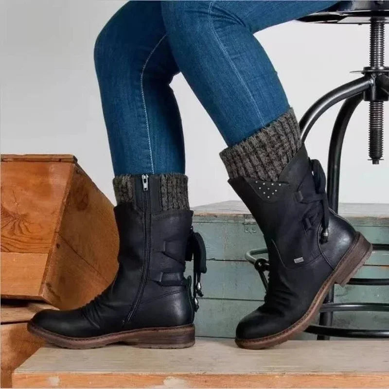 Black boots worn with jeans, showing side lacing and the opposite zip.