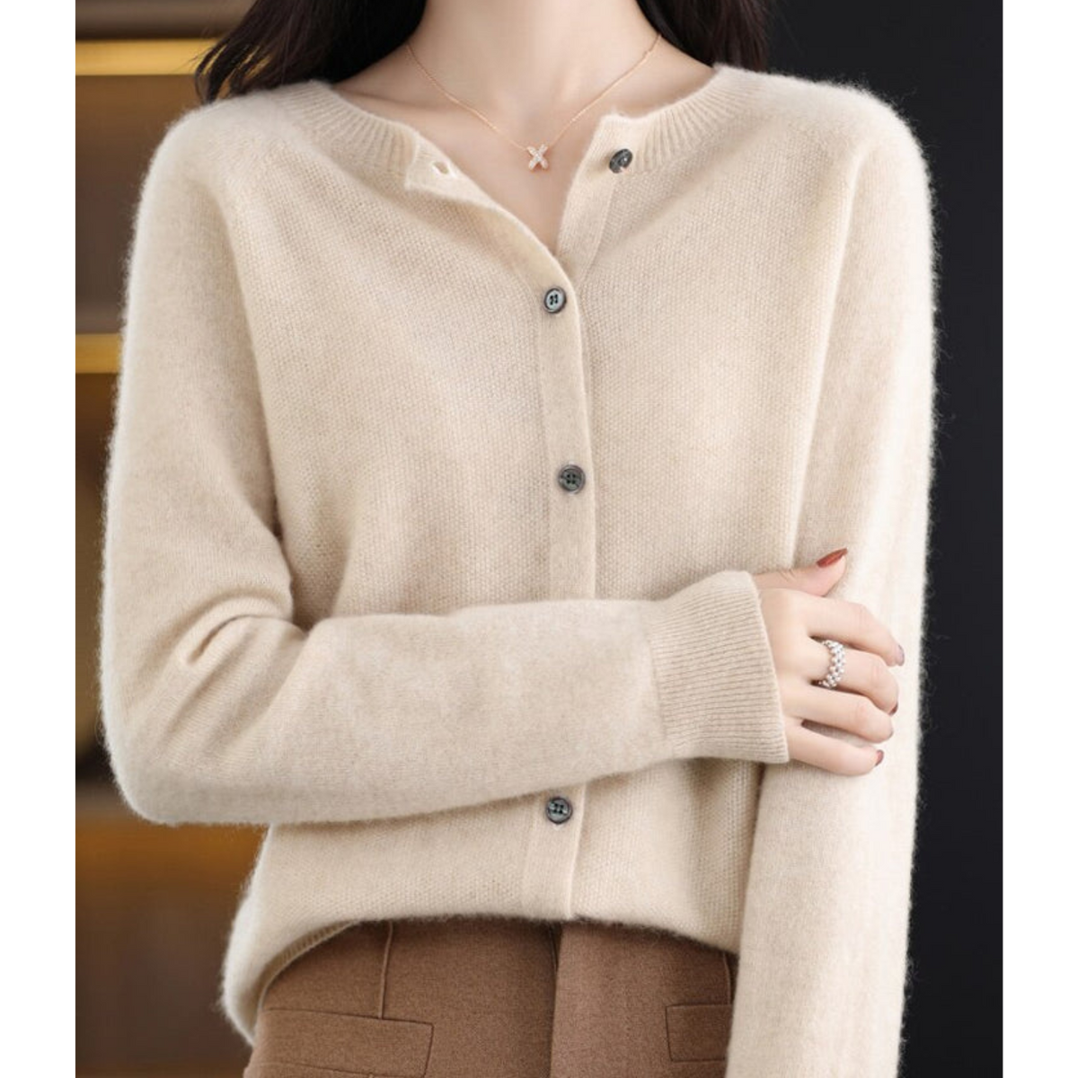 Light neutral cardigan with a round neckline and small front buttons.