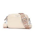 Beige shoulder bag with a wide patterned strap and front pocket.