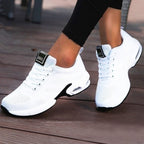 White lace-up trainers with textured uppers and curved contrasting soles.