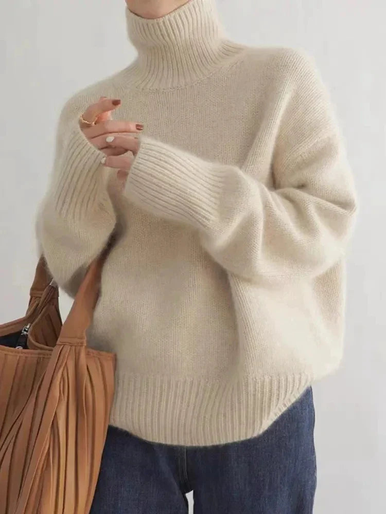 Cream-toned roll-neck sweater with ribbed cuffs and hem, worn with jeans.