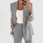 Grey blazer and matching trousers worn over a white top.