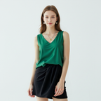 Green sleeveless Trigala top worn with black shorts.