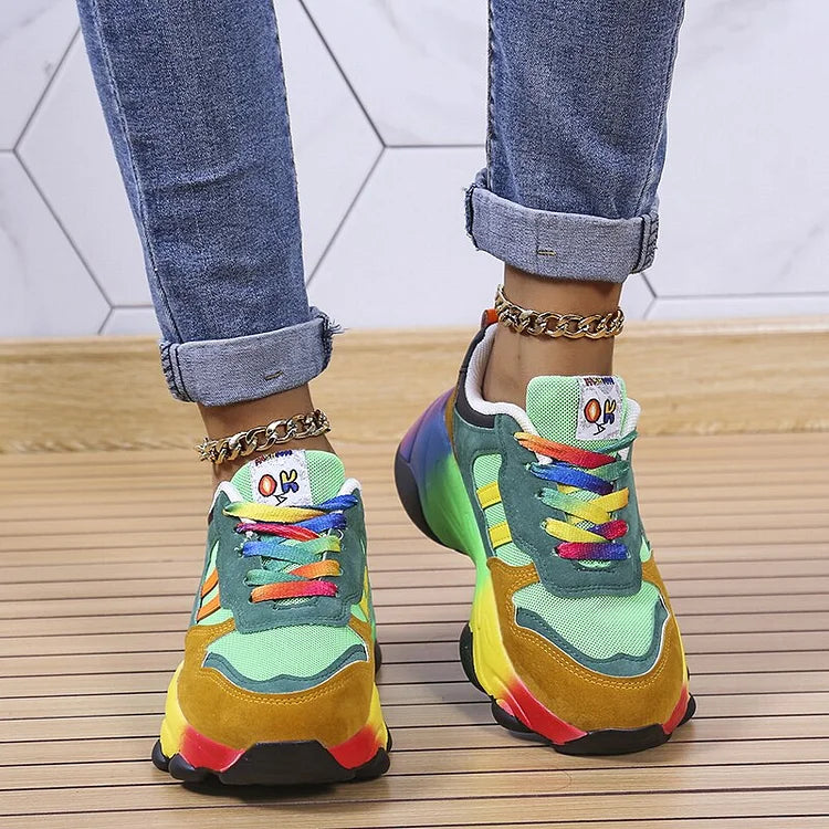 Green colourblock sneakers with rainbow laces, shown from above.