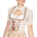 White lace blouse worn beneath a pale lace-up dirndl dress.
