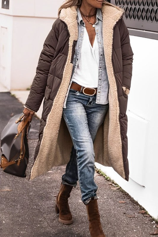 Brown long coat worn open to show a cream teddy lining.