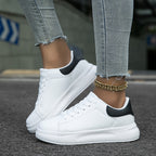 White and black trainers showing the low-cut opening and thick soles.