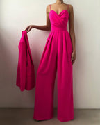 Rose-red jumpsuit shown with a matching jacket in hand.
