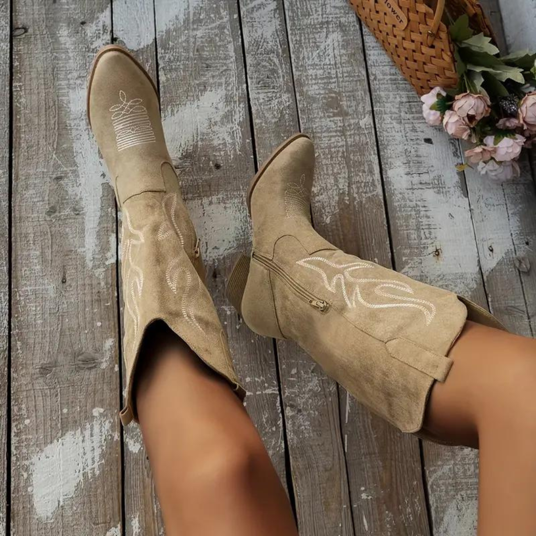 Sand-coloured cowboy boots viewed from above, with pale stitching and side zips.