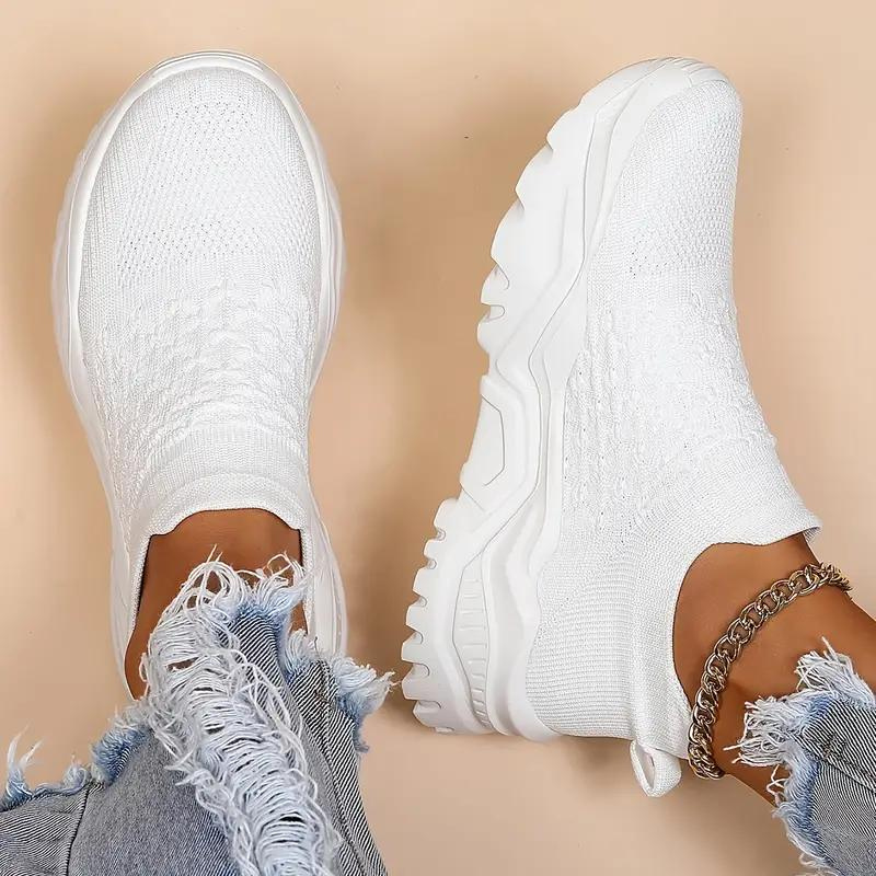 White trainers shown from above, with heel loops and patterned uppers.