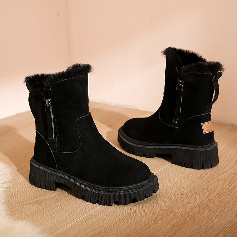 Black boots on a wooden surface, showing a side zip and rear loop.