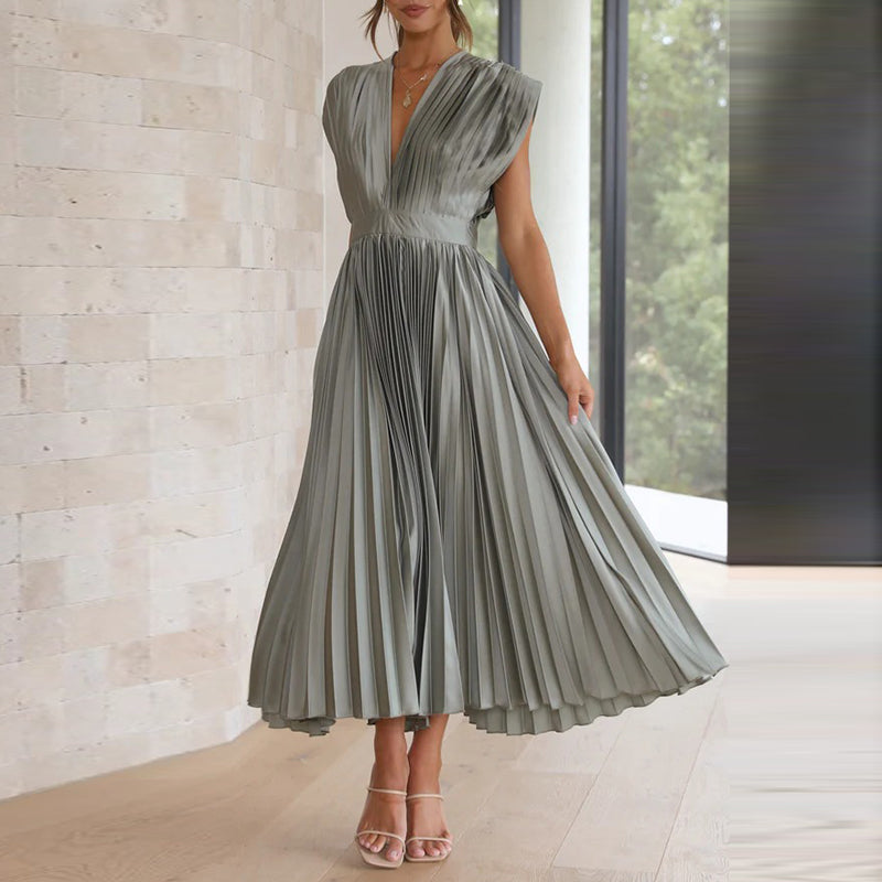 Grey dress with the pleated skirt held out to one side.