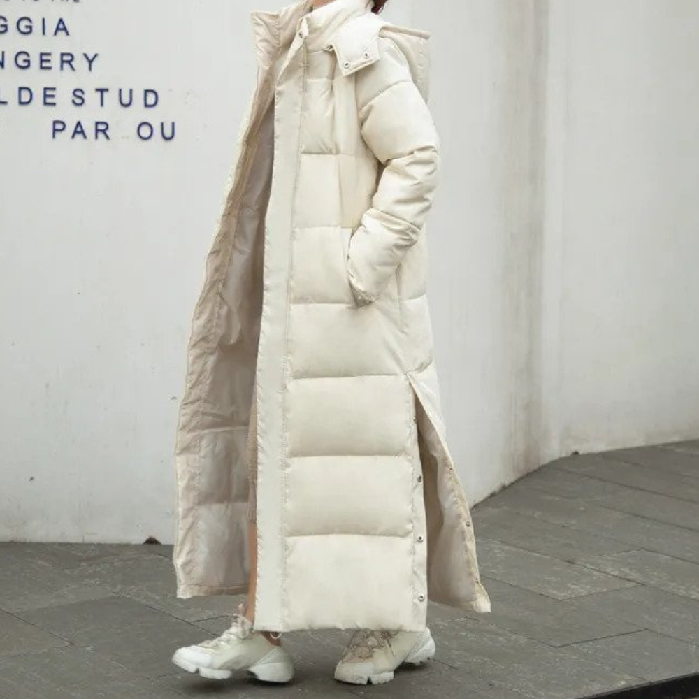 Beige long quilted hooded coat with side pockets, shown being worn.