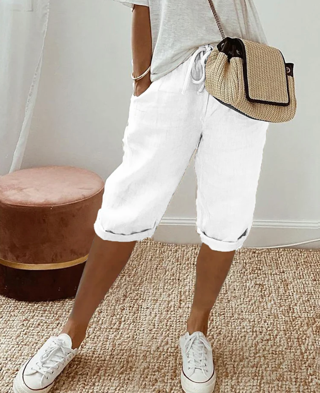 White drawstring shorts with knee-length legs and turned-up hems.