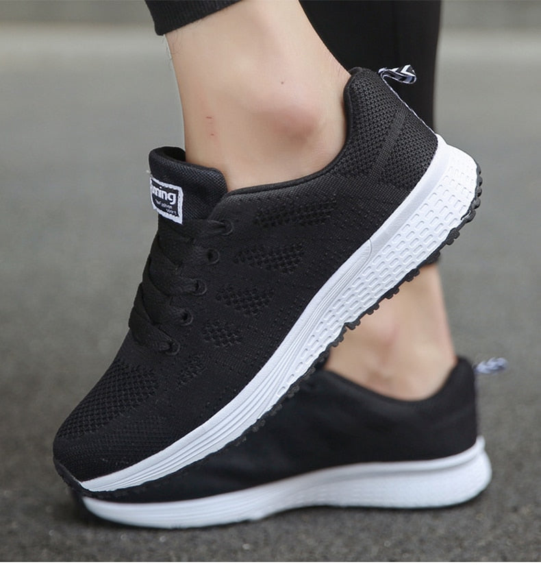 Black lace-up trainers with white soles and small rear loops.