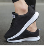 Black lace-up trainers with white soles and small rear loops.
