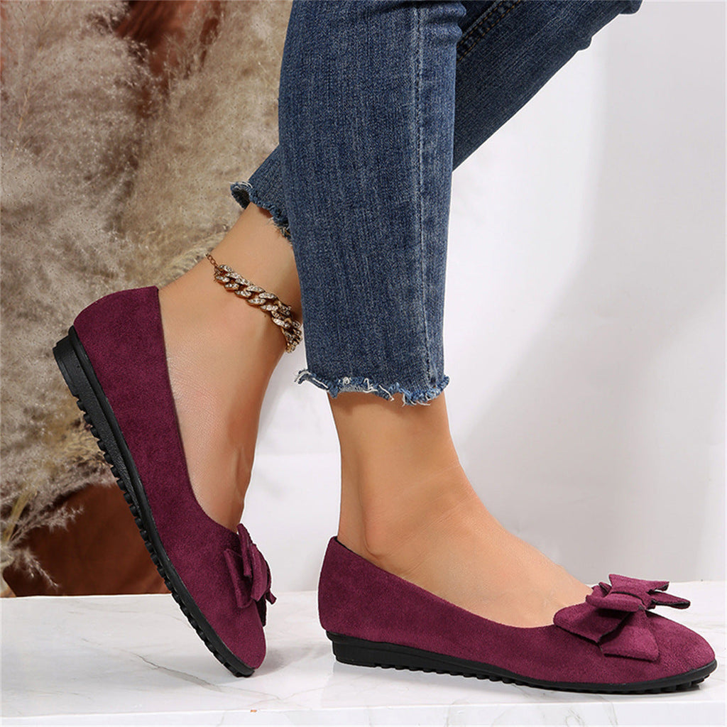 Burgundy bow-front flats worn with jeans.