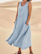 Sky blue sleeveless dress with a loose long skirt and front pockets.