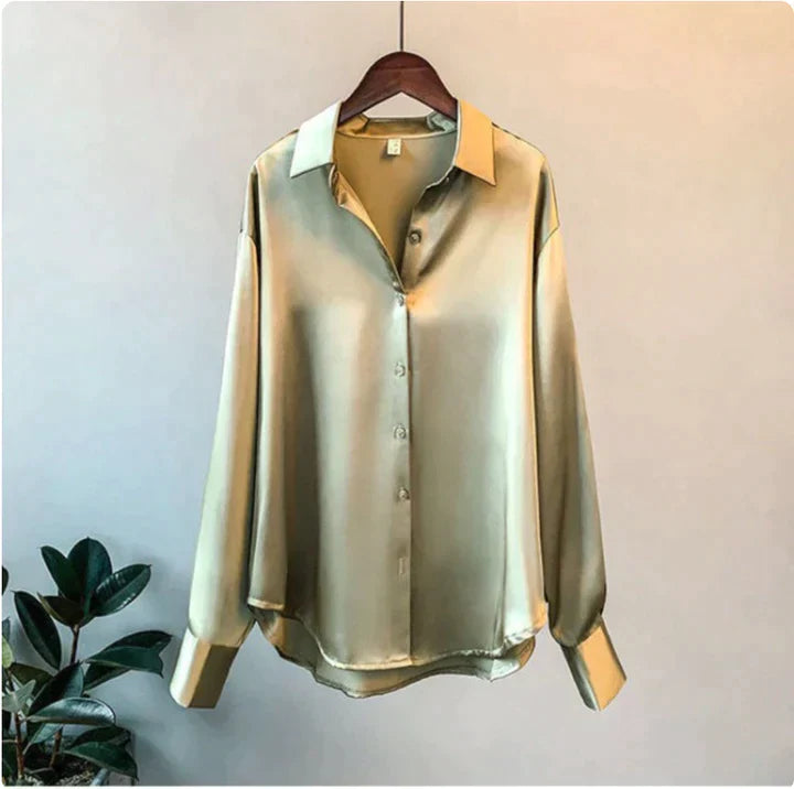 Olive green shirt with a relaxed shape and button-through front on a hanger.