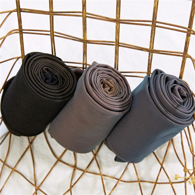 Three pairs of tights rolled to show dark and neutral colours.