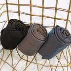 Three pairs of tights rolled to show dark and neutral colours.
