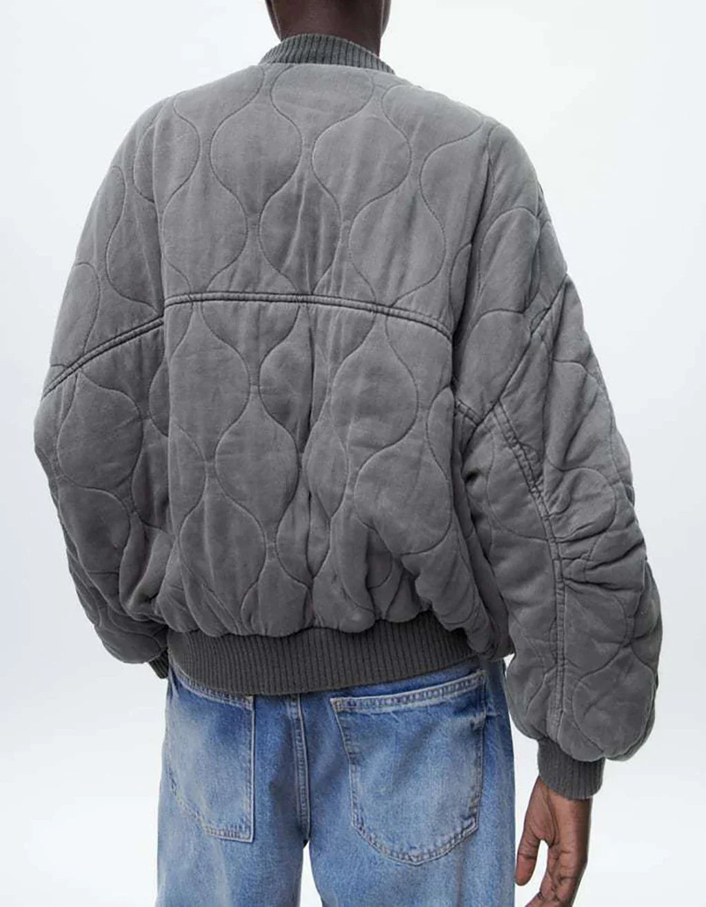 Rear worn view showing the jacket’s loose sleeves and gathered hem.