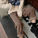 Grey-brown ribbed trousers shown while seated.