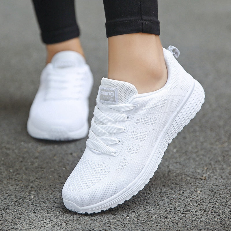 White mesh-textured trainers with white laces and thick white soles.