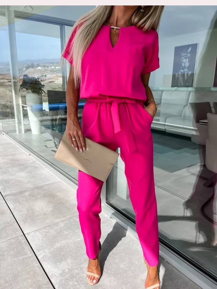Rose-red jumpsuit with short sleeves and a tied waist.