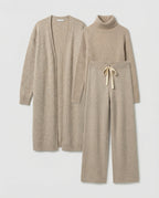 Three beige knit pieces laid flat, with a roll-neck top and tied trouser waistband.