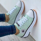 Pale green lace-up trainers with white soles and toe caps.