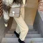 White ribbed trousers shown from the side on steps.