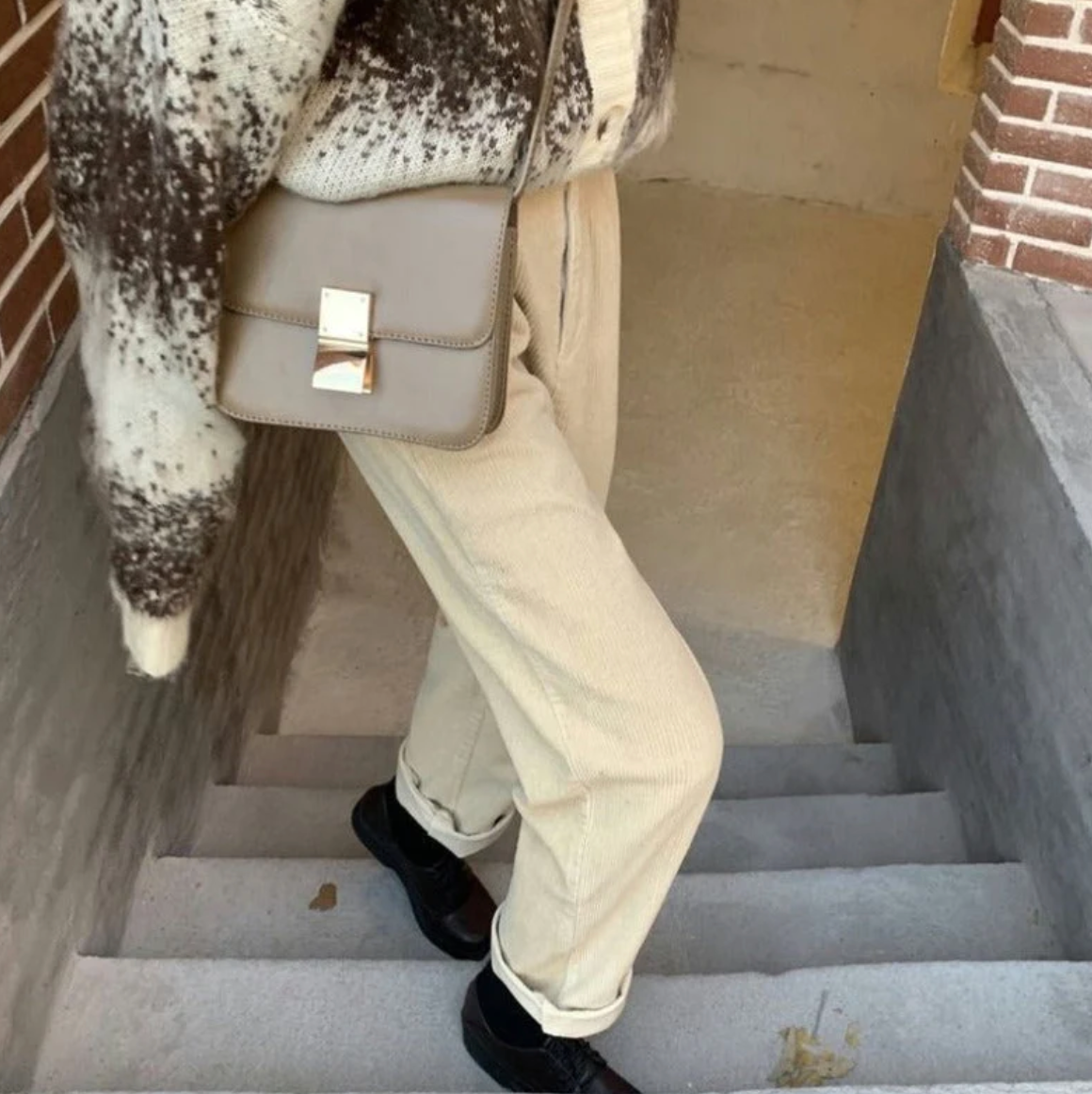 White ribbed trousers shown from the side on steps.