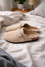 Pale grey-beige clogs with closed toes and open heels.